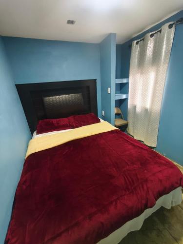 a bedroom with a bed with a red comforter at Don Cruz Places in Ensenada