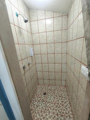 a bathroom with a shower with a tiled floor at Don Cruz Places in Ensenada