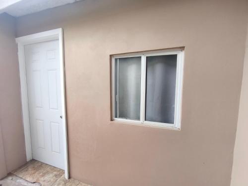an empty room with a window and a door at Don Cruz Places in Ensenada