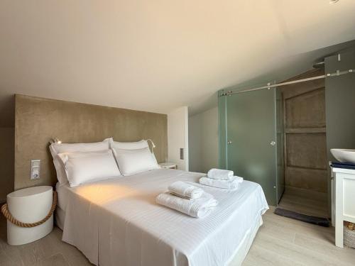 a bedroom with a bed with towels on it at Dimeli - Sea View Villas in Foinikounta in Finikounta