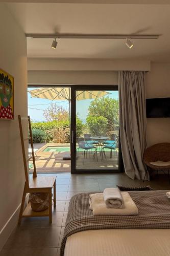 a bedroom with a bed and a view of a patio at Dimeli - Sea View Villas in Foinikounta in Finikounta