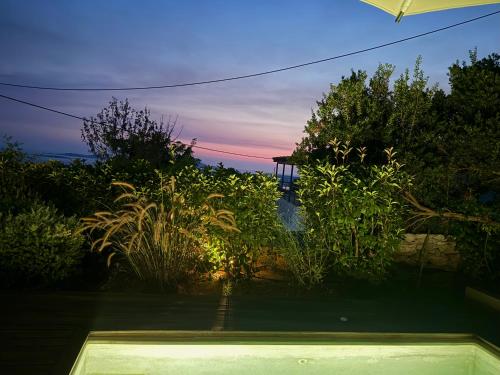 a view of a garden at sunset from a house at Dimeli - Sea View Villas in Foinikounta in Finikounta