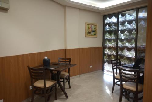 a dining room with a table and chairs and a wine cellar at Master Gold Hotel Express in Cascavel