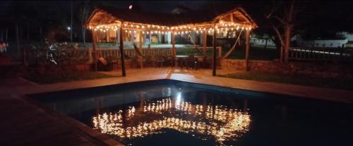 a pool with christmas lights in a yard at night at San Rafael del Campo - Barichara in Barichara