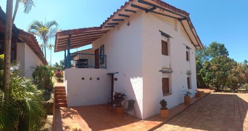 a white house with a gate and palm trees at San Rafael del Campo - Barichara in Barichara