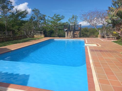 a large blue swimming pool in a backyard at San Rafael del Campo - Barichara in Barichara