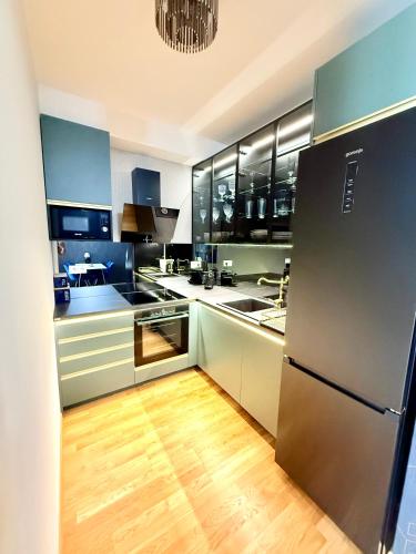 a kitchen with stainless steel appliances and wooden floors at Andy's apartment in downtown Metropolis with parking in Nivy