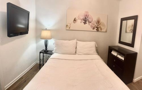 a small bedroom with a bed and a tv at 3 Bedrooms Florida Sunshine in Pompano Beach