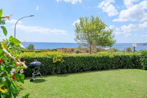 een barbecue die in het gras naast een heg staat bij Villa 19 in Santa Cesarea Terme