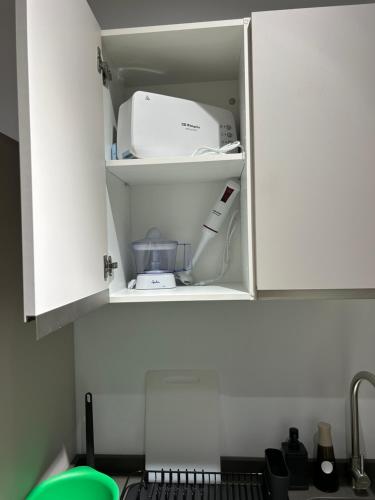 a kitchen cupboard with a printer and other items inside at Casa Cuatro Esquinas in Utrera