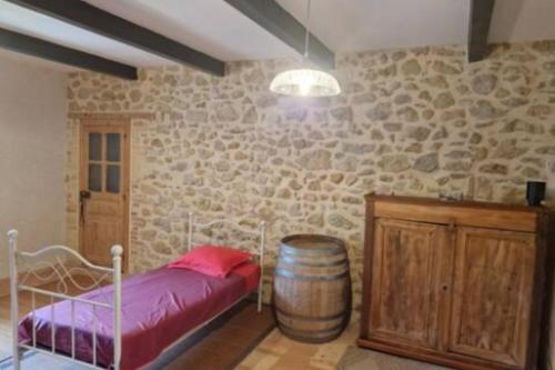 a bedroom with a bed and a wine barrel at Grand mas provençal 4 chambres, dortoir 7 pers, idéal familles groupes, fraîcheur d'été in Montfaucon
