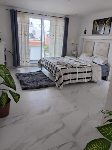 a bedroom with a bed and a large window at Vertice in San Luis Potosí