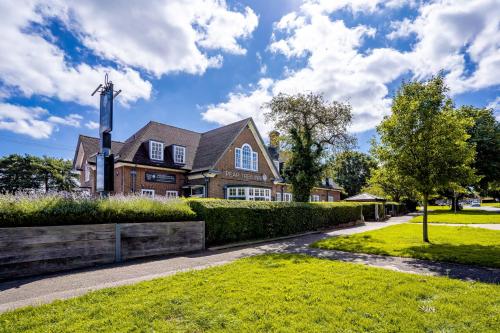 a house with a cross in the front yard at Pear Tree Inn in Welwyn Garden City