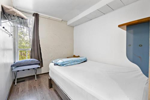 ein kleines Schlafzimmer mit einem Bett und einem Fenster in der Unterkunft Margaritaville - Big Space with Lots of fun and Hot Tub 38R in Blue Mountains