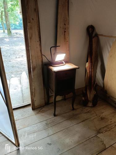 a lamp sitting on a table next to a door at tipy 2 in La Celle-sous-Gouzon