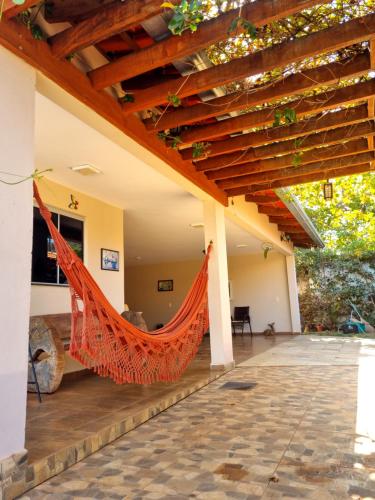 an outdoor patio with a hammock under a pergola at Casa Morro do Frota, Pirenópolis in Pirenópolis