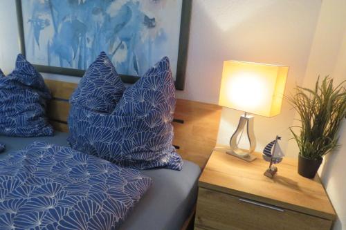 a bedroom with a bed with blue pillows and a lamp at Ferienwohnung mit Terrasse in Schellhorn in Schellhorn