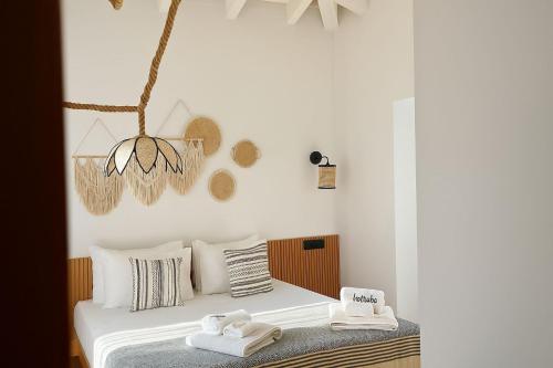 a bedroom with a bed with two towels on it at Kotraba Alacati Hotel in Alacati