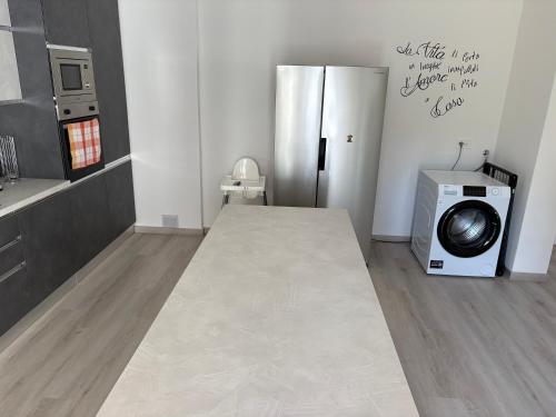 a kitchen with a refrigerator and a washing machine at Tominettihome in Verbania