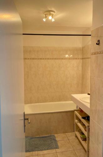 une salle de bain avec une baignoire et un lavabo dans l'établissement Parc de Diane ANTIBES RDJ, à Antibes