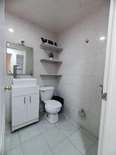 a bathroom with a toilet and a sink and a mirror at Vertice in San Luis Potosí