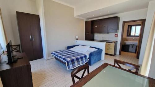 a bedroom with a bed and a table and a kitchen at Spazio Accogliente dove il tempo si ferma in Livorno