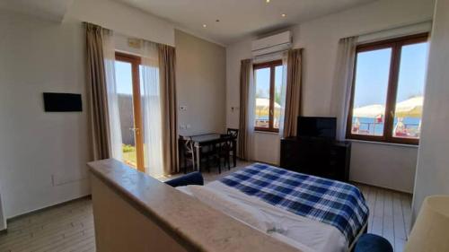 a bedroom with a bed and a table and windows at Spazio Accogliente dove il tempo si ferma in Livorno