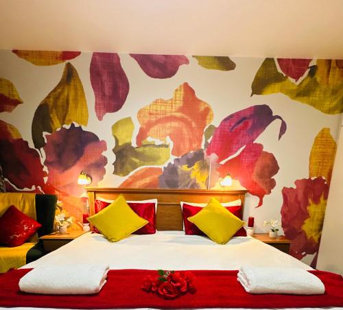 a bedroom with a bed with red and yellow pillows at Liza Luxury Holiday Apartment Oceanic 44 in Durban