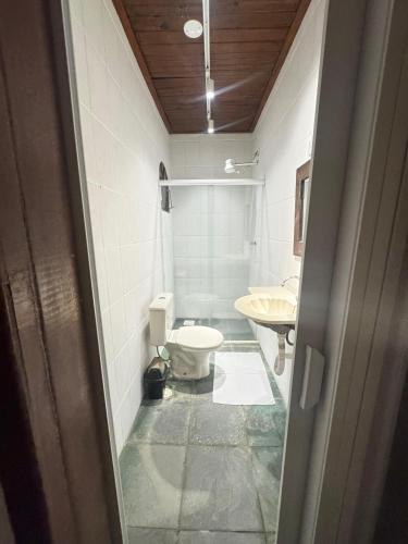 a bathroom with a toilet and a sink at Pousada Barra do Sahy in Barra do Sahy