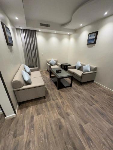 a living room with two couches and a coffee table at راجان للشقق المخدومة in Taif