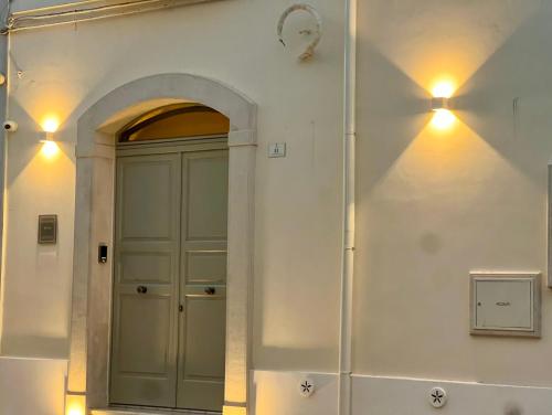 a door in a white wall with lights on it at Dhome in Fasano