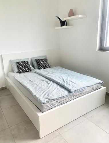 a white bed in a white room with a mattress at AirbnbTřeboň - modern apartment in Třeboň