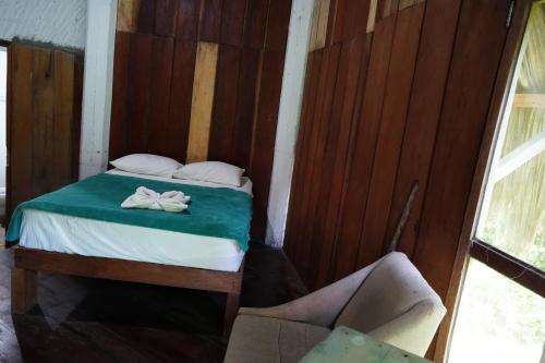 a bedroom with a bed and a chair in it at Eco Hotel Sak Nok in Lacanjá