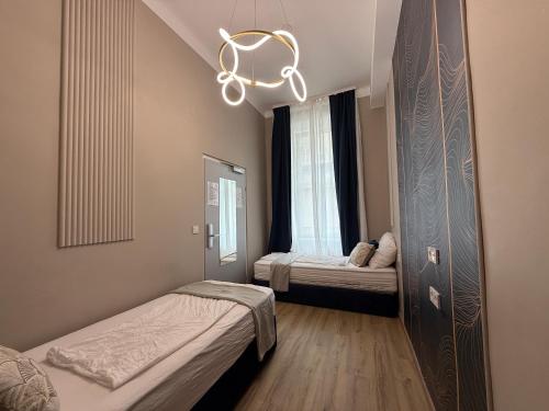 a small room with two beds and a chandelier at Nestroyplatz Rooms I Self Check In in Vienna
