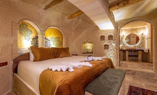 a bedroom with a large bed with towels on it at Lagoon Cave Suites in Urgup