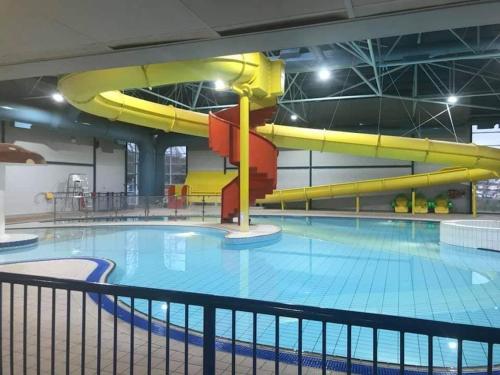 a large swimming pool with a yellow slide at Hoburne Devon Bay Fabulous 3 bedroom caravan, with decking in Goodrington