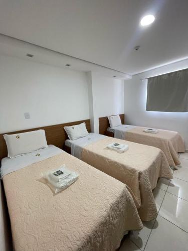una habitación con tres camas en una habitación en Hotel Prime Suites, 