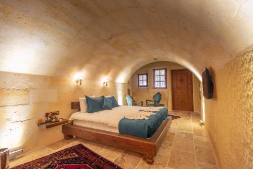 a bedroom with a large bed in a stone wall at Lagoon Cave Suites in Urgup