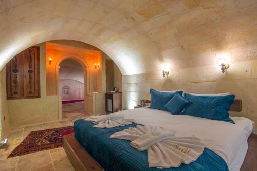 a bedroom with a large bed with towels on it at Lagoon Cave Suites in Urgup
