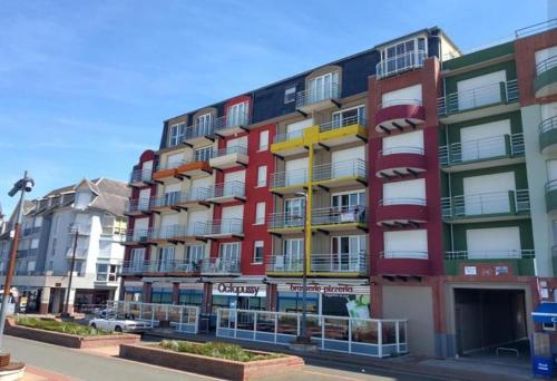 a tall building with colorful balconies on a street at Face à la mer by Corinne in Mers-les-Bains