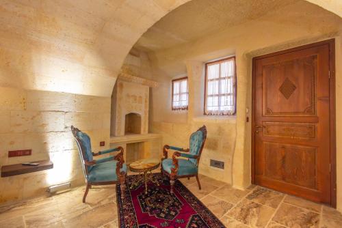 a room with two chairs and a table and a door at Lagoon Cave Suites in Urgup
