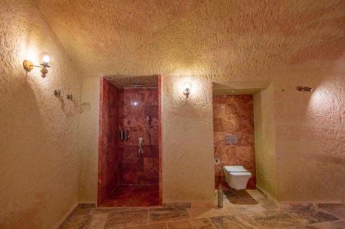 a bathroom with a toilet and a red door at Lagoon Cave Suites in Urgup