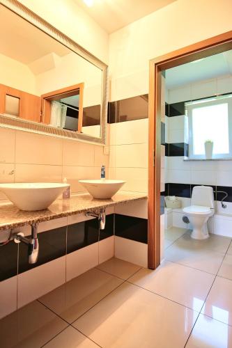 a bathroom with two sinks and a toilet at Solna Chata-dom na wyłączność Grota solna, balia, sauna, basen in Rajcza