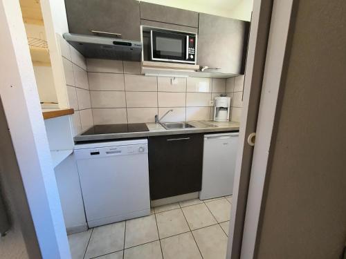 une petite cuisine avec un évier et un micro-ondes dans l'établissement Chalets Jardin Alpin - Chalet mitoyen lumineux · Accès pistes par navette · Wifi gratuit MAE-5014, à La Salle Les Alpes