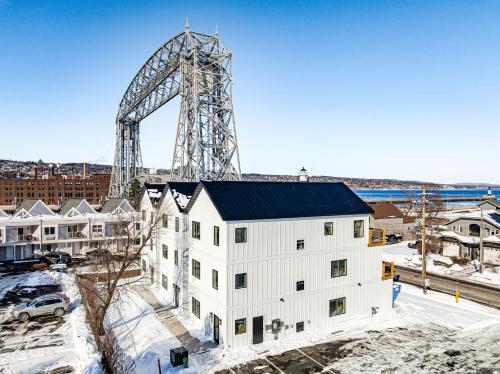 an overhead view of a white building with a large crane in the background at Dragestil 713 Duluth Luxury Condos by Heirloom Boutique Collection in Duluth