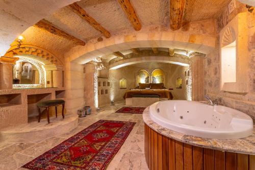 a large bathroom with a tub and a bedroom at Lagoon Cave Suites in Urgup