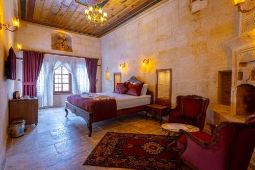 a bedroom with a bed and a chair in a room at Lagoon Cave Suites in Urgup