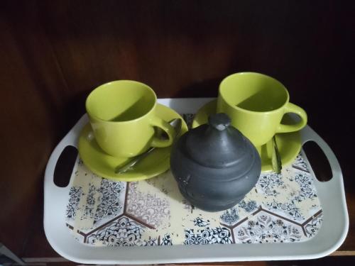 a tea pot and two cups on a table at Hostel Trinidad in San Salvador de Jujuy