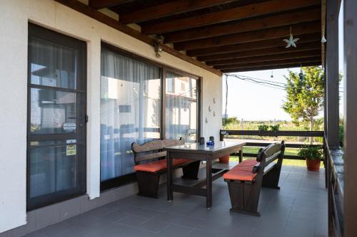 Un patio con una mesa y sillas en un porche. en Hacienda del Mar'a, en Vama Veche