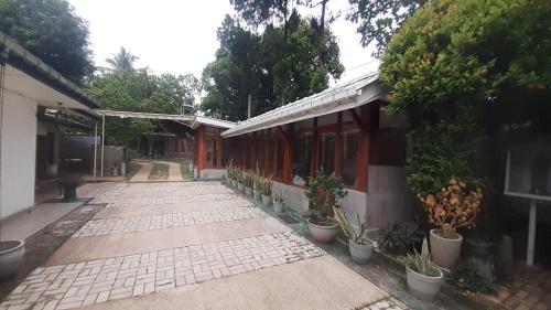 a walkway next to a building with potted plants at The Garden Resort Airport Katunayaka in Katunayake